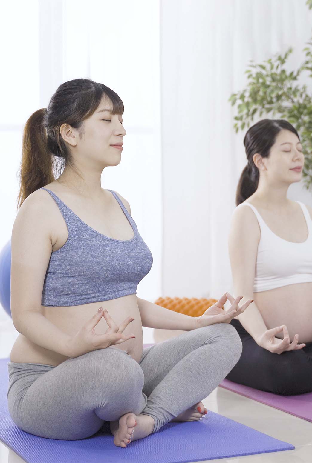 マタニティの女性が軽い運動（ヨガ）を楽しみ出産に備える様子